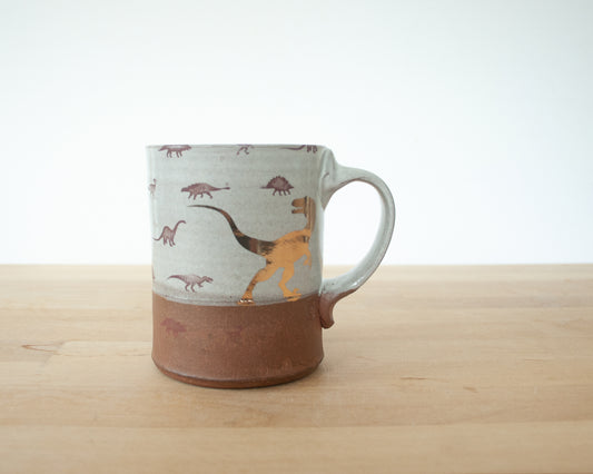 Gold Velociraptor mug with little dinosaurs