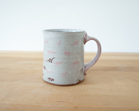 Mug with small pink and brown dinosaurs