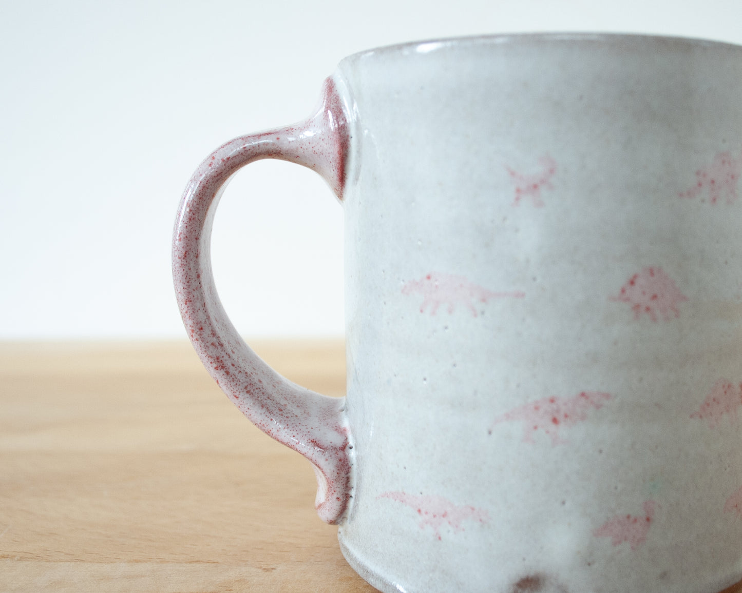 Mug with small pink and brown dinosaurs