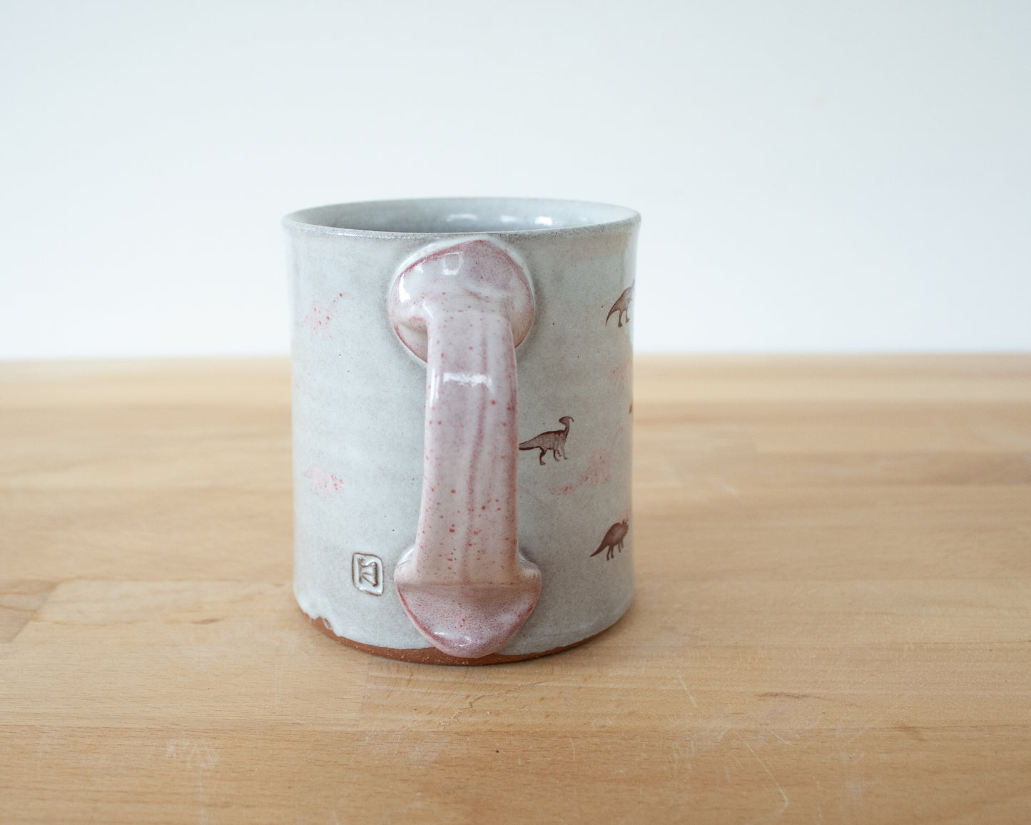 Mug with small pink and brown dinosaurs