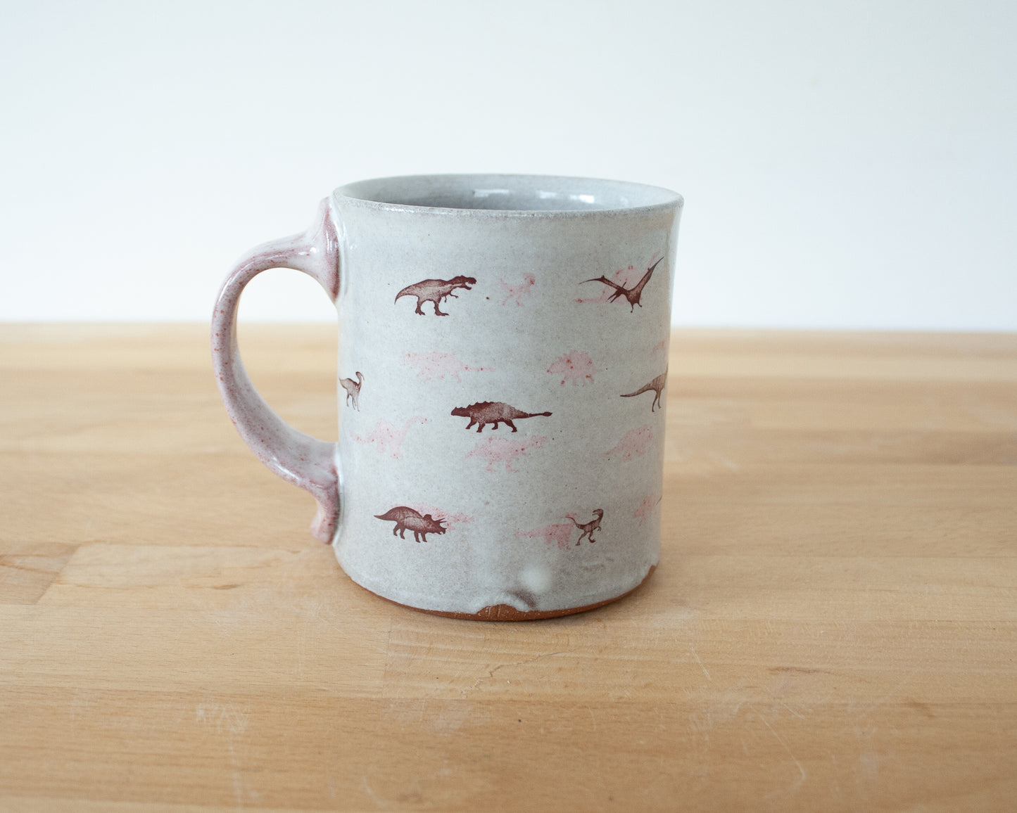 Mug with small pink and brown dinosaurs