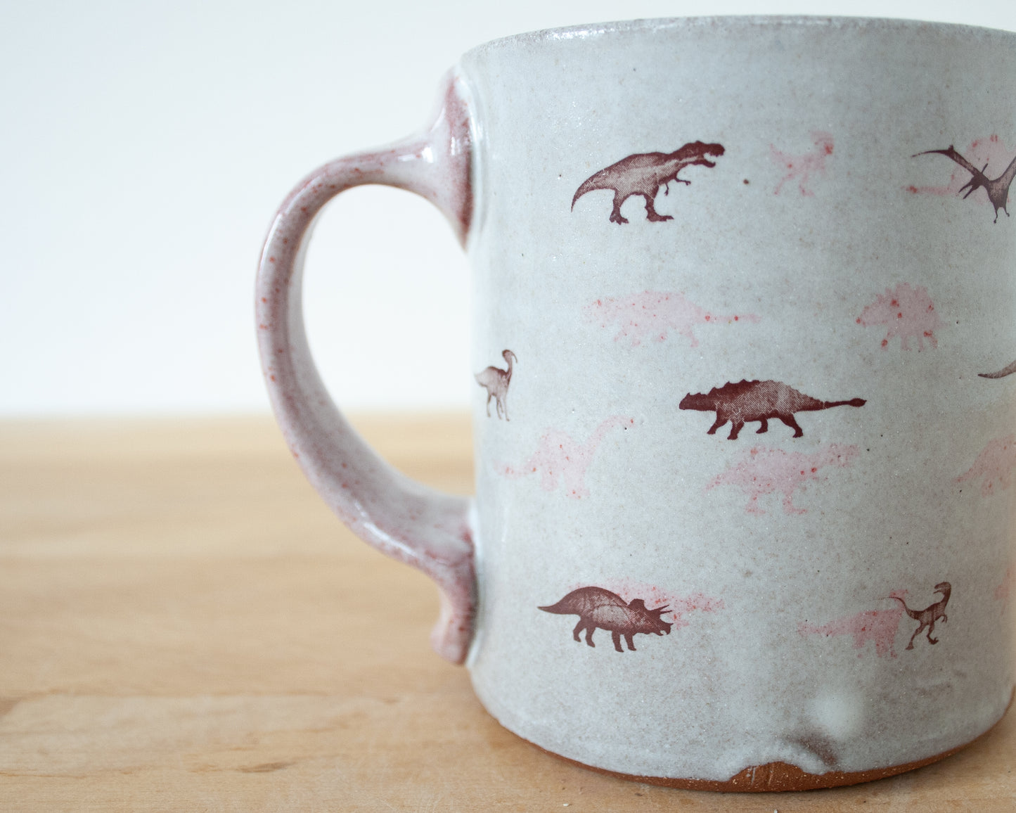 Mug with small pink and brown dinosaurs